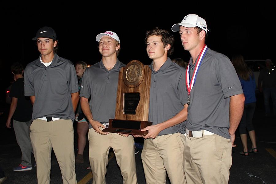 Golf team members Miles Gifford, Trey DePriest, Dax Hurst and Andrew McFarlin display their state trophy Tuesday night at the school parking lot. Members of the community were on hand when the team arrived back home to welcome them and congratulate them on their state title. The team received a police and fire department escort and were greeted by mayors of all three towns in the school district.