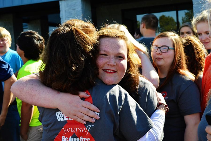 Senior Maria Hart embraces EAST instructor Jill Sanders after the balloon release. Hart was one of the organizers of the event and spoke candidly about her family's struggles with addiction. 