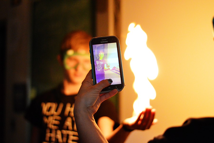 Teacher Stephanie Woods films Junior J.J. Ivy holding a flame during an experiment in class. Each student enrolled in chemistry had the opportunity to try this experiment.
