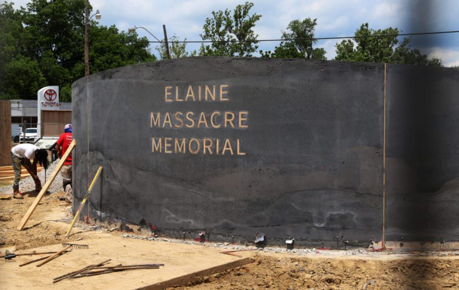 In this June 15, 2019, photo, men work near a monument under construction honoring victims of the Elaine Massacre that sits across from the Phillips County courthouse in Helena, Ark. The Elaine Massacre Memorial is set to be unveiled in September and is being chaired by some descendants of the massacres perpetrators and victims. (AP Photo/Noreen Nasir)