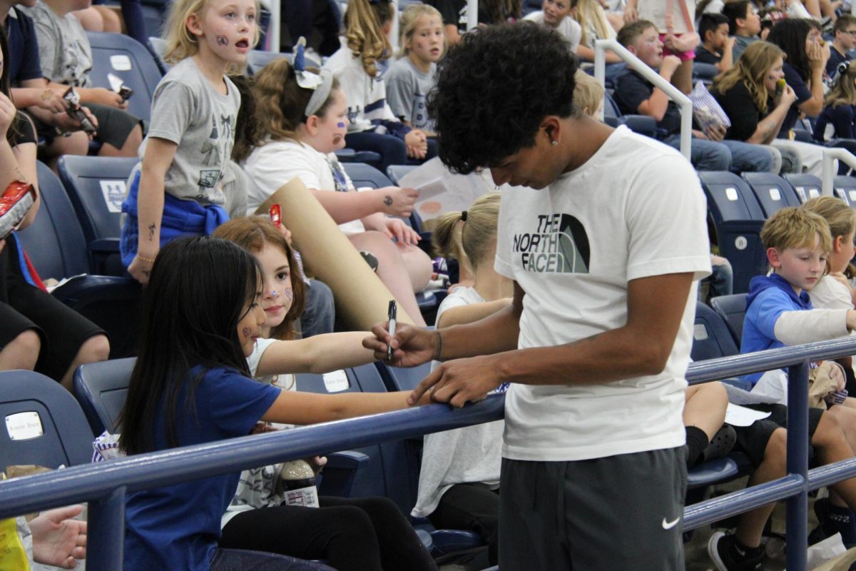 Senior Leonardo Contreras signs autographs for elementary students prior to taking the court in the 2026 Blue/Gray game.